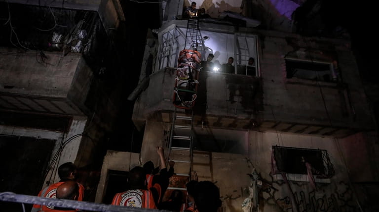 Palestinian civil defence members evacuate survivors of the Israeli bombardment...