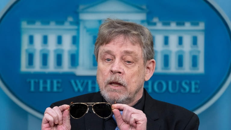 Actor Mark Hamill takes off sunglasses given to him by...