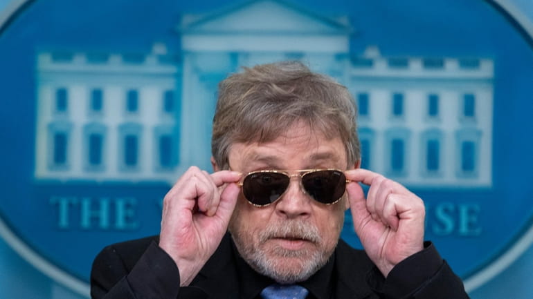 Actor Mark Hamill takes off sunglasses given to him by...