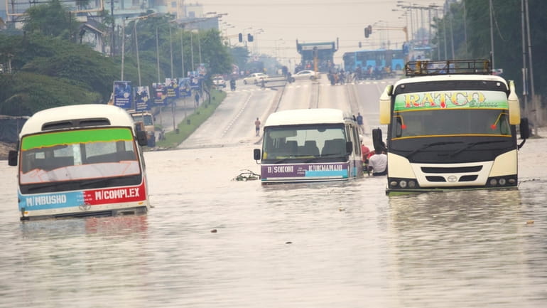 Public minibus are submerged in the flooded streets of Dar...