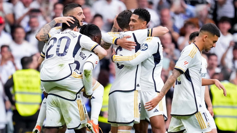 Real Madrid's Jude Bellingham, center right, celebrates after scoring his...
