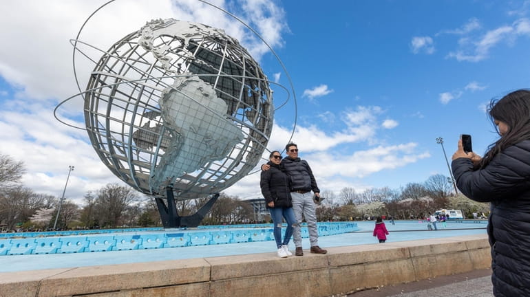 Visitors take pictures at the Unisphere, which was built for...